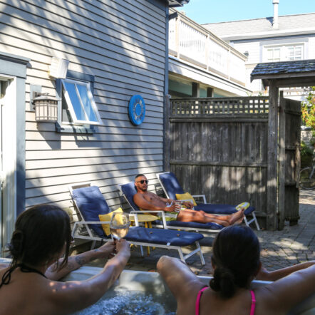 People relaxing in hot tub and sun chairs