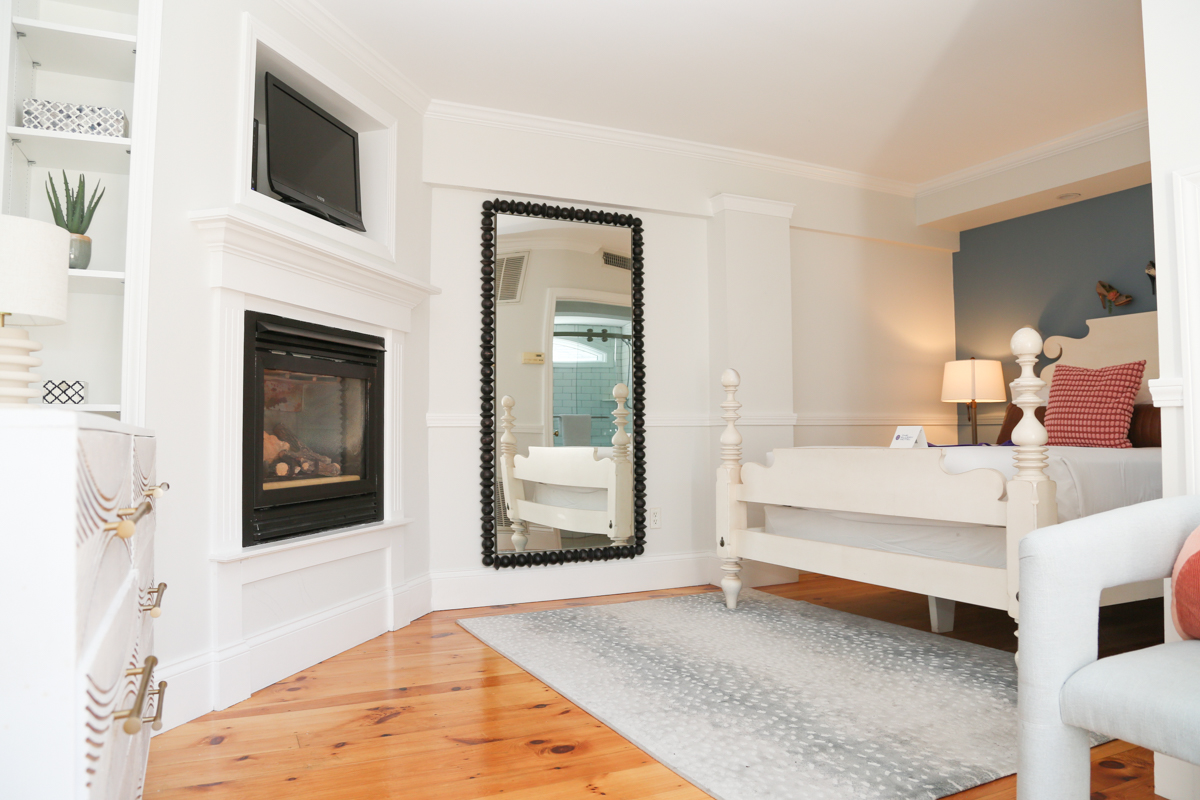 Bright bedroom with a fireplce and large mirror