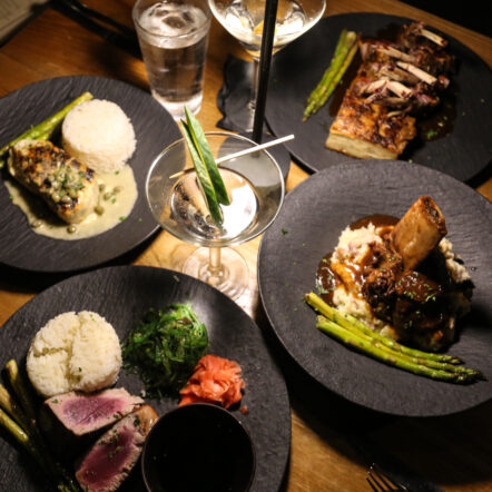 Plates of gourmet food with drinks on table