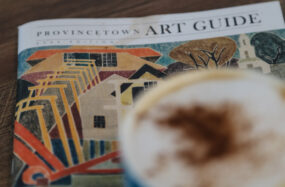 Art guide and cofe cup on table