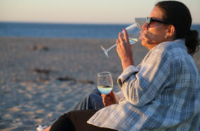 Two persons drinking white wine on the beach