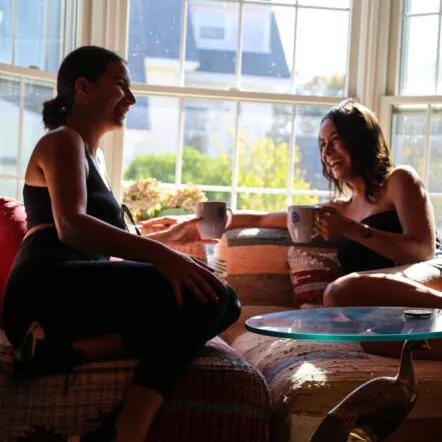 Two women chatting over coffe by a sunny window