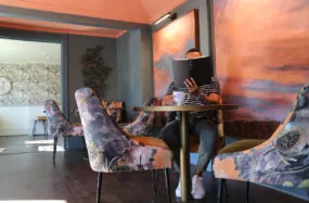 Person reading at a colorful indoor lounge