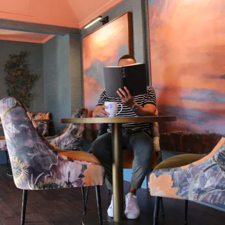 Person reading at a colorful indoor lounge