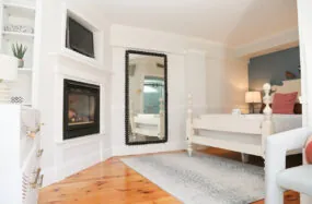 Bright bedroom with a fireplce and large mirror
