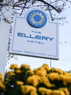 Ellery Hotel sign with yellow flowers and tree branches