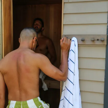 Man entering sauna with towel